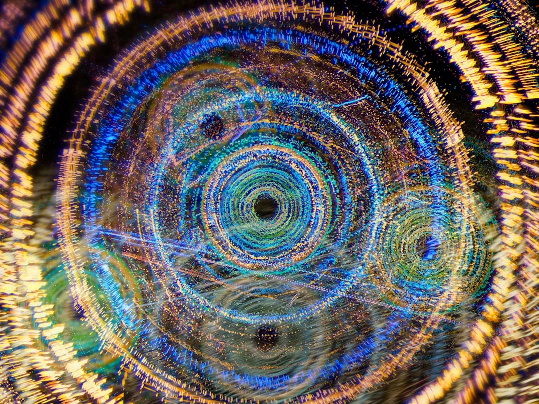 Abstraktes Bild mit konzentrischen Kreisen und wirbelnden Mustern in Blau, Gold und Weiß, das einen lebendigen, dynamischen visuellen Effekt hervorruft, der an Lichtspuren oder Energiefelder erinnert - ein künstlerischer Ausdruck der inneren Erleuchtung.