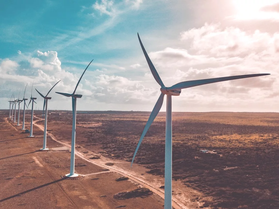 Eine Reihe von Windkraftanlagen steht in einer trockenen, offenen Landschaft unter einem teilweise bewölkten Himmel und zeigt die effiziente Energieerzeugung mit erneuerbarer Energie.