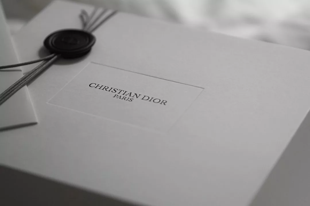 Eine weiße Schachtel mit einem "Christian Dior Paris"-Etikett, verschnürt mit schwarzem Band und versiegelt mit einem schwarzen Wachsstempel - perfekt für eine gelungene Selbstpräsentation oder um erfolgreich aufzutreten.