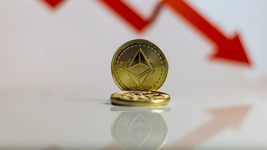 Zwei Ethereum-Münzen ruhen auf einer spiegelnden Oberfläche mit einem roten Abwärtspfeil im Hintergrund, der eine Wertminderung symbolisiert - ähnlich wie bei den Trends auf den Aktienmärkten, wenn sich wichtige Grundlagen ändern.