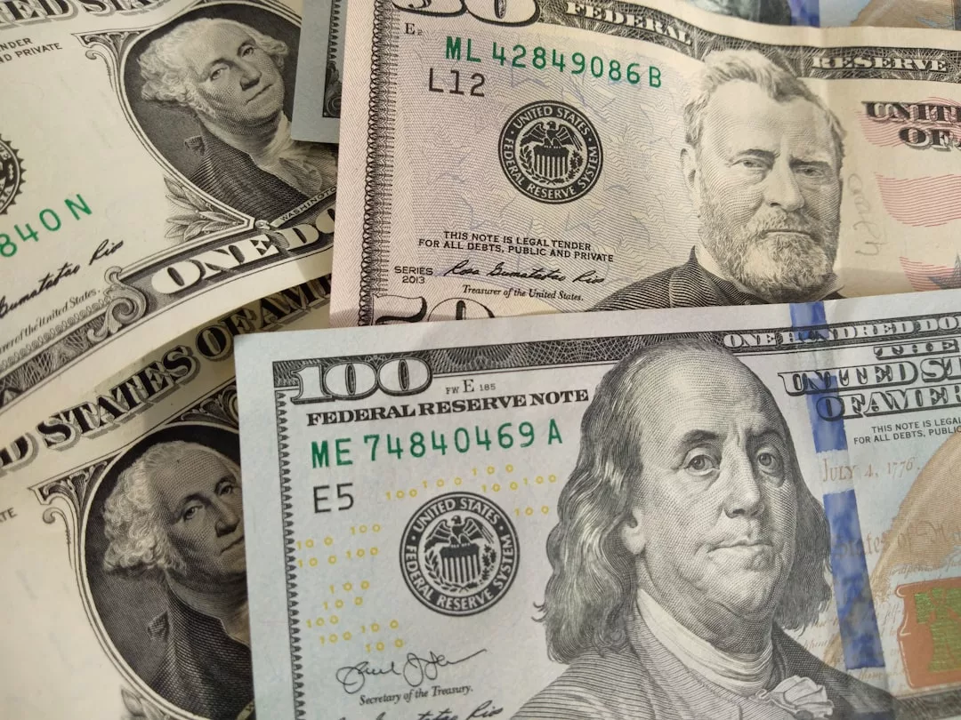 Nahaufnahme einer US-Währung, darunter 1-, 50- und 100-Dollar-Scheine, die sich teilweise überlappen - ein visuelles Symbol für finanzielle Sicherheit und Vorsorge im Ruhestand.