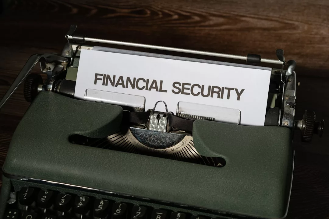 Ein Blatt Papier mit der Aufschrift "FINANZIELLE SICHERHEIT" ist in eine alte Schreibmaschine auf einer dunklen Holzoberfläche eingelegt und symbolisiert finanziellen Schutz durch zeitlose Werkzeuge.