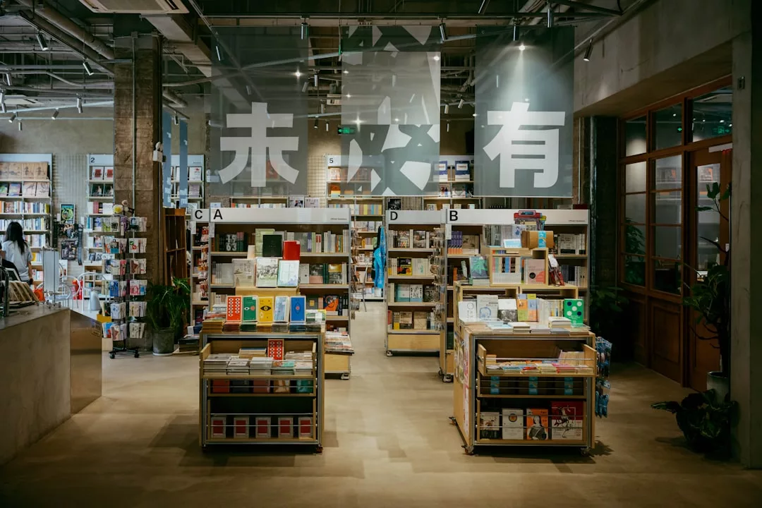Innenraum einer modernen Buchhandlung mit geordneten Bücherregalen, heller Beleuchtung und großen chinesischen Schriftzeichen an der Glaswand im Hintergrund, die die Bedeutung kultureller Bildung hervorheben.