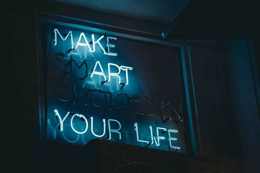 Ein blaues Neonschild mit der Aufschrift "MAKE SMART CHOICES IN YOUR LIFE" (Triff kluge Entscheidungen in deinem Leben) ist an einer dunklen Wand angebracht - eine inspirierende Erinnerung an die Investition in eine kreative Zukunft.