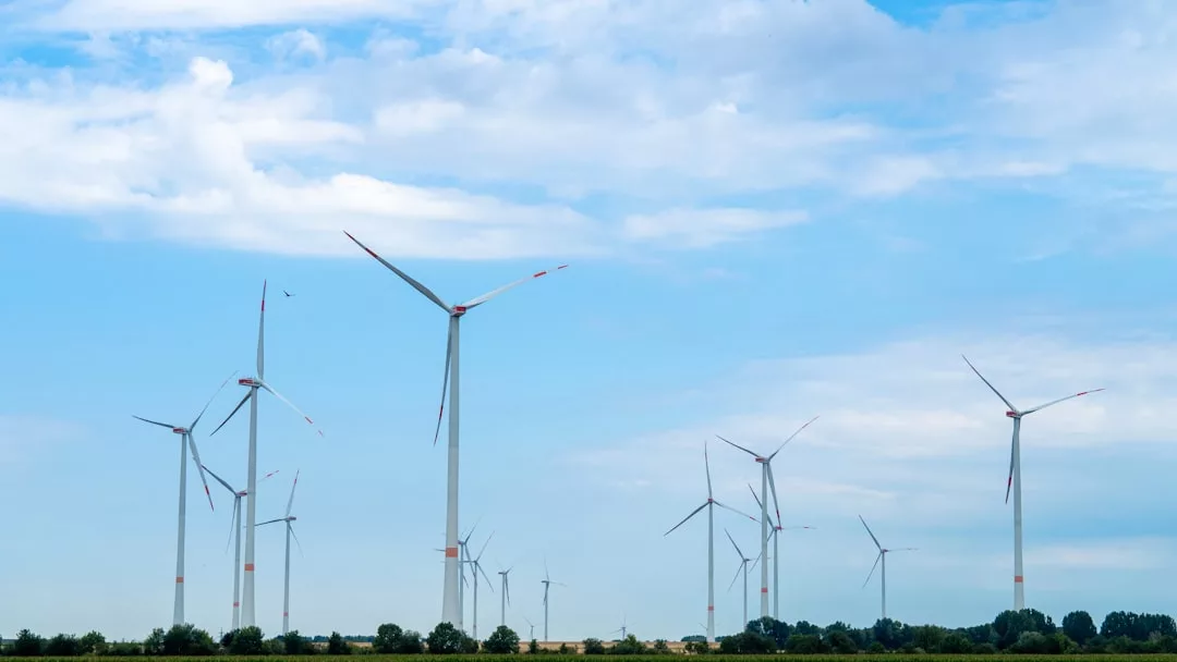 Mehrere Windkraftanlagen stehen auf einer Wiese unter einem teilweise bewölkten Himmel und erzeugen nachhaltige Energie für eine saubere Zukunft.