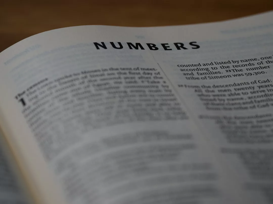 Eine aufgeschlagene Bibel zeigt den Anfang des Buches Numeri, mit dem Titel "NUMBERS" deutlich sichtbar am oberen Rand - eine Einladung zum Nachdenken über Numerologie und die Macht der Zahlen in biblischen Texten.