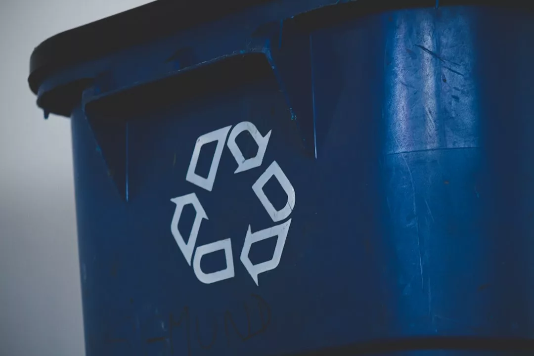 Eine Nahaufnahme einer blauen Recycling-Tonne mit einem weißen Recycling-Symbol an der Seite, das auf die Bedeutung von Recycling und einem achtsamen Umgang mit Abfall hinweist.