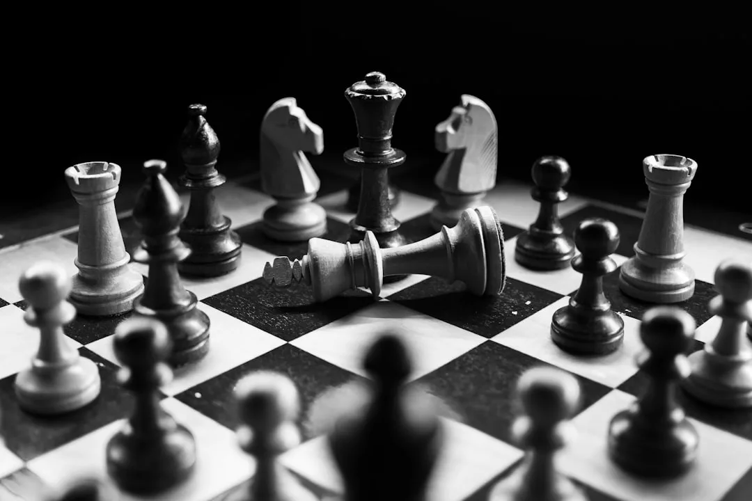 Ein Schachbrett mit verschiedenen Figuren; der weiße König liegt auf der Seite und symbolisiert Lernhindernisse, während der schwarze König aufrecht in der Mitte steht und Strategien zur Überwindung illustriert.