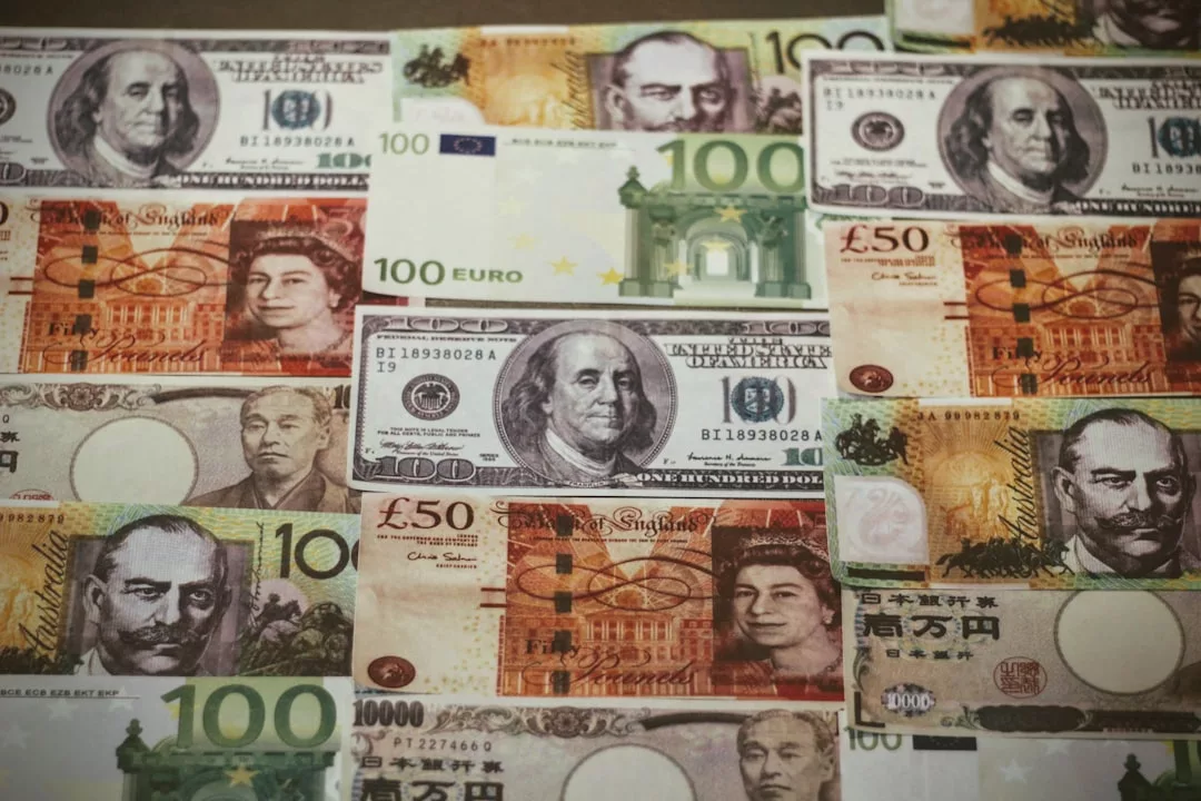 Verschiedene internationale Banknoten, darunter US-Dollar, britische Pfund, japanische Yen und Euro, in einem Raster angeordnet - ideal für die Analyse von Währungsinvestitionen und Strategien.