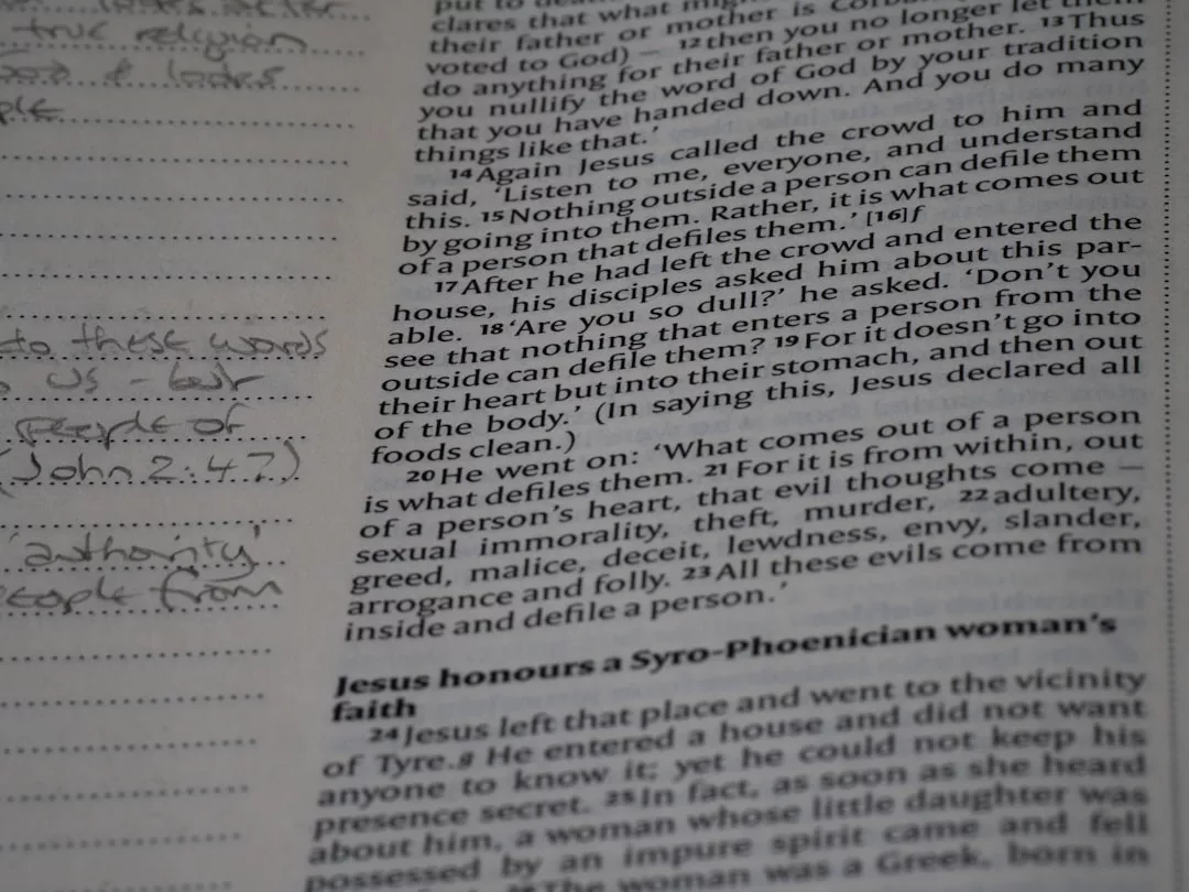 Eine Nahaufnahme einer Bibelseite, die Markus 7,15-23 zeigt, mit handschriftlichen Notizen am Rand auf der linken Seite - eine inspirierende Szene für wissenschaftliches Schreiben oder diejenigen, die eine Forschungsarbeit schreiben wollen.